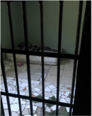 A cell with tile floors and metal bars